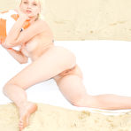 Third pic of Marvelous blonde hottie posing in the nude with an inflatable ball outdoor on the sand.