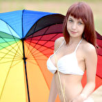 First pic of Fascinating redhead nymph with impressive tits posing with a big gaudy umbrella outdoors.