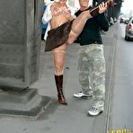 Third pic of Blonde Angie in nylons, boots and mini skirt shows her bald pussy in the street