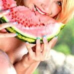 Second pic of Redhead babe Violla A poses nude outdoors as she is chomping down on a watermelon 