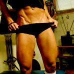 Second pic of Dark haired bodybuilder Tara Scotti in black uniform shows off her muscle torso