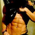Third pic of Dark haired bodybuilder Tara Scotti in black uniform shows off her muscle torso