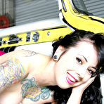Third pic of Tattooed gothic brunette Nikki 666 strips out of pink of yellow car hood