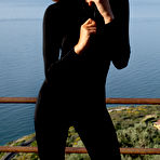 First pic of Teddy posing outdoor in black bodysuit, high heels and sunglasses
