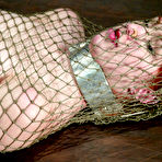 Third pic of Slim redhead Calico Slave gets wrapped in fishnet and dunked in water tank after spanking