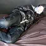 Second pic of Shinynylonartsbound | ***SEXY SONJA*** being tied and gagged on a bed with ropes and a clothgag wearing a sexy black shiny nylon down jacket and a black shiny nylon rain pants (Video)