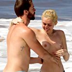 First pic of Miley Cyrus caught topless on a beach