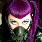 Fourth pic of Flirtatious Natalie Addams with purple hair and smooth pussy poses in black latex outfit