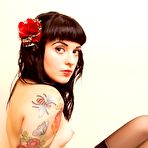 Second pic of Black haired inked up alt girl Dizzee in pink platform shoes poses on office chair