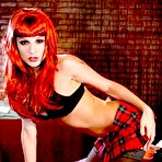 First pic of Baring her plaid skirt and black lingerie sassy redhead Kirsten Price poses in stockings