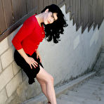 First pic of Brunette Mary Jane in black skirt and red blouse exposes her feet outdoors
