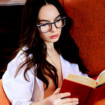 First pic of Nude Nerdy Debora A flaunts her sexy, slender body while reading on the chair.