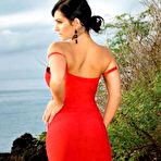 Second pic of Denise Milani posing outdoor in red dress