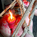 Second pic of SexPreviews - Nikki Nymph submissive in red with pantyhose is bound with clamps and candle waxed