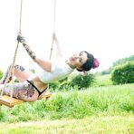 Second pic of Tattooed babe Aemelia showing her tight ass on outdoor swing | Erotic Beauties