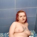 Third pic of Tattooed redhead touches herself in the bathroom - AmateurPorn