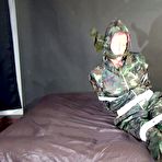 Fourth pic of Shinynylonartsbound | Watching sexy Pia being tied and gagged with tape on a bed wearing a sexy camouflage shiny nylon rainpants and a rainjacket as well as yellow rubber boots (Video)