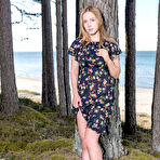 First pic of Nice teen Sara unveils her full breasts while going nude under a seaside tree