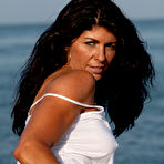 Fourth pic of Bodybuilder Tara Caden models on a beach while wearing a wet shirt