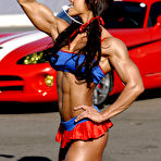 Third pic of Bodybuilder Patricia Beckman flexes her muscles in front of a sports car