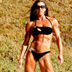 First pic of Bodybuilder Lynnie Brooks poses on sandy ground in a bikini and sunglasses