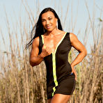 First pic of Asian bodybuilder Tram Nguyen flexes in the outdoors while wearing dresses