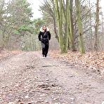 First pic of Solo girl Natasha Ink squats for a pee on a dirt road in glasses and a coat