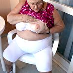 Second pic of Obese grandmother GrandmaLibby parts her labia lips after disrobing on balcony