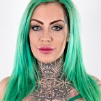 Second pic of Tattooed girl with green hair and pierced nipples stands naked after disrobing