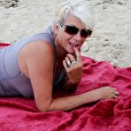 Fourth pic of Beautiful busty mature Dimonty poses fully clothed in sheer dress at the beach