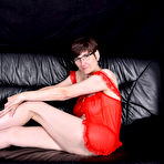 First pic of Mature brunette gets totally naked on a sofa while wearing glasses