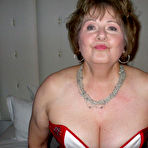 Fourth pic of Mature woman Busty Bliss looses her big tits from a corset by her condo window