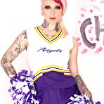 First pic of Tattooed chick Scarlet Lavey works free of a cheerleader outfit to pose naked