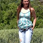 First pic of Older brunette NicolD whips down her blue jeans to piss in the tall grass