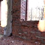 Fourth pic of Blonde chick squats for a piss by an abandoned brick building