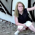 Third pic of Caucasian female squats for an urgent piss by a graffiti-covered wall