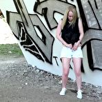 Fourth pic of Caucasian female squats for an urgent piss by a graffiti-covered wall