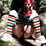 Second pic of Young blonde Larisa takes a pee behind a tree in multi-coloured knee socks