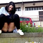 Second pic of Dark-haired chick Lora pulls down her leggings to pee over a retaining wall