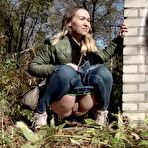 Second pic of Short taken girl pulls down her jeans to take a piss by a brick building