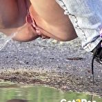 Third pic of Petite brunette Natasha squats for a piss in a puddle on a gravel road