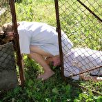 First pic of Caucasian girl straddles a man's face outside of a doghouse in a yard