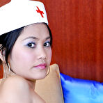 Third pic of Petite Latina nurse Joana lifting top to expose small breasts