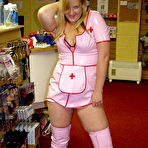 Second pic of Blonde amateur Samantha works free of a latex nurse outfit in a sex shoppe