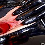 Second pic of Latex attired female Latex Lucy sucking vibrator before inserting it in twat