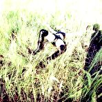 Third pic of Latex clad chick is tied up and masturbated in long grass at old brick factory