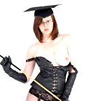 Fourth pic of Pale redhead releases a boob from leather attire while wearing a mortar board