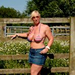 First pic of Busty mature slut Melody sheds bikini top outdoors to sun massive tits