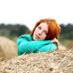 First pic of Natural redhead Amber A poses her naked teen body on round bale of hay