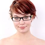 Third pic of Nerdy redhead wears a mischievous smile while getting naked for the first time